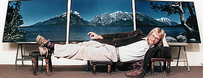 RL reclines in front of a large triptych of the Tetons.